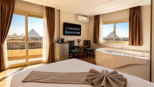 a hotel room with a tub and a view of the pyramids at Royal Pyramids View Inn in Cairo