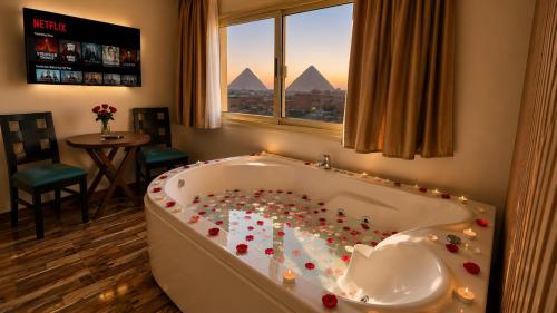a tub in a room with a view of the pyramids at Royal Pyramids View Inn in Cairo