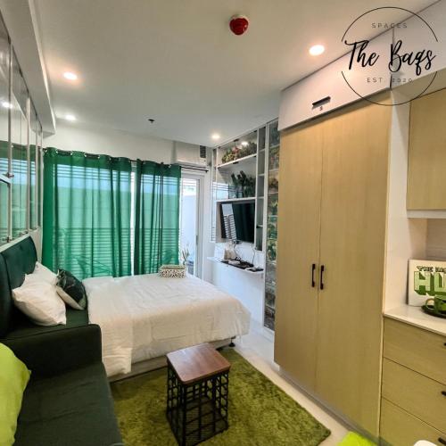 a bedroom with a bed and a green curtain at Marvel Fan Studio Condo with Pool CDO TheBaqs in Balulang