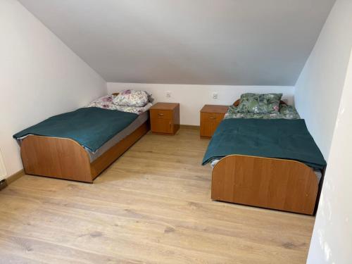two beds in a small room with wooden floors at Hostel in Piotrków Trybunalski