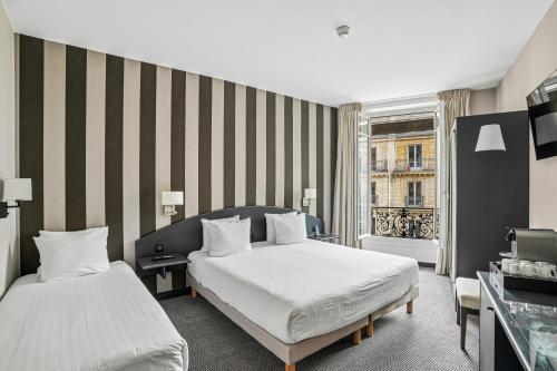 a hotel room with two beds and a window at Excelsior Opera in Paris