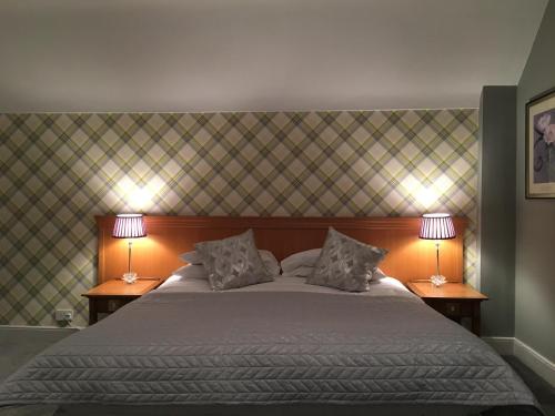 a bedroom with a large bed with two lamps at The Coach House Inn in Chester