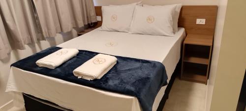 a bedroom with a bed with two towels on it at Hotel New City in Guarulhos