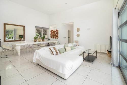 a white living room with a white couch and a table at Can Drago in Ibiza Town