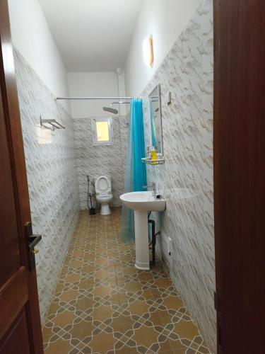 a bathroom with a sink and a toilet at Le Rivage de Sérénité in Sali Nianiaral