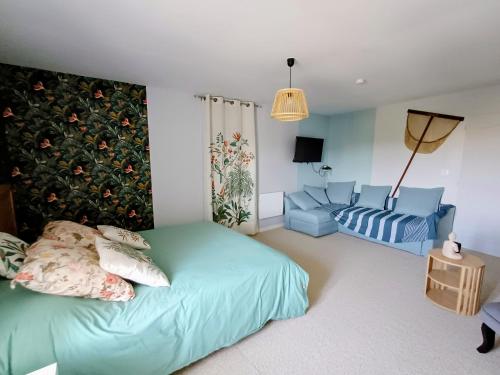 a bedroom with a bed and a couch at Chambre d'hôte ColChris in Saint-Pierre-le-Vieux