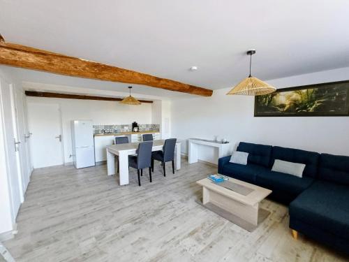 a living room with a blue couch and a table at Chambre d'hôte ColChris in Saint-Pierre-le-Vieux