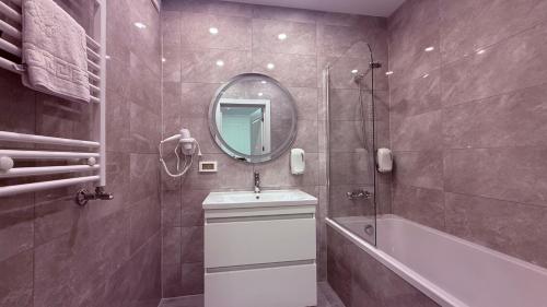 a bathroom with a sink and a tub and a mirror at Apartment OneClickRent 16 in Chişinău