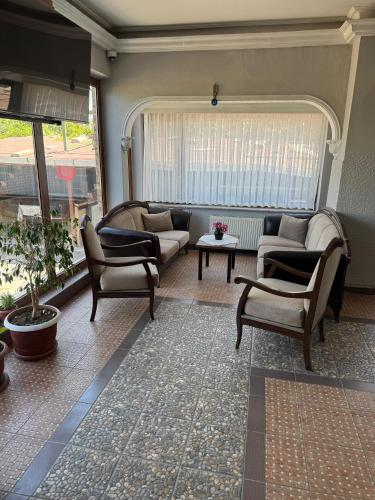 a living room with a couch and chairs and a window at Aslanlar Otel in Tekirdağ