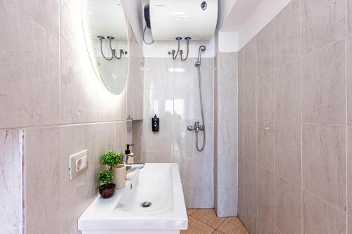 a white bathroom with a shower and a sink at Dhermi's Icon Big 1BR Apt 10 in Dhërmi