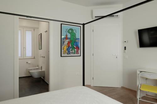 a white room with a bed and a bathroom at VItruVIo POP in Fano