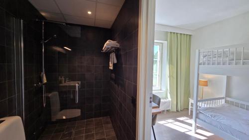 a bathroom with a shower and a bedroom with a bed at Norrqvarn Hotel & Resort by Vänerport in Lyrestad