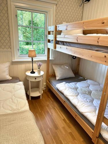 two bunk beds in a room with a window at Hus Bjöksjöblick in Hällefors