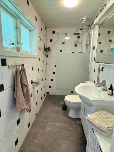 a white bathroom with a sink and a toilet at Hus Bjöksjöblick in Hällefors