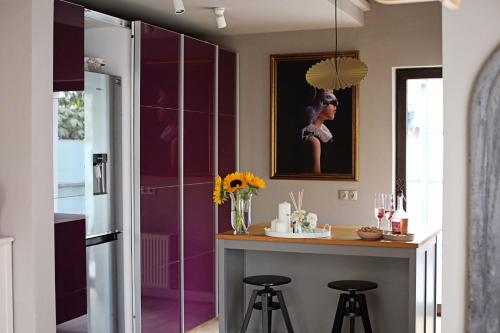 a kitchen with purple walls and a counter with stools at Moft Loft. Lovely, comfy apartment. in Cluj-Napoca