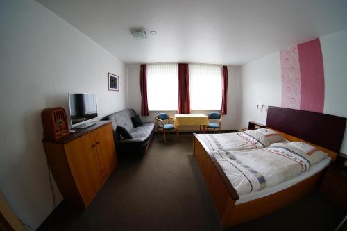 ein Hotelzimmer mit einem Bett und einer Couch in der Unterkunft Hotel Werdumer Hof in Werdum