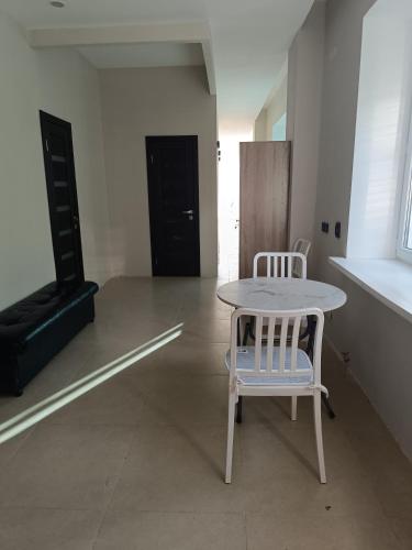 a white table and a chair in a room at Urban hostel Saryarka in Astana