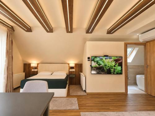 a bedroom with a bed and a tub in a room at Platán Panzió in Dobogoko