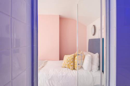 a mirror in a room with a bed with pillows at Spacious 3BR Family Home with Big Garden in Manchester