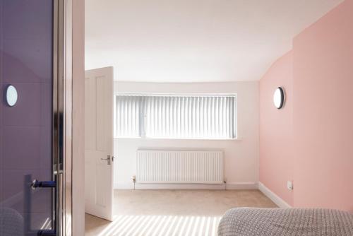 a bedroom with a bed and a window with a radiator at Spacious 3BR Family Home with Big Garden in Manchester