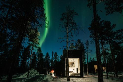 an igloo under the aurora in the woods at Polaris Villas - Villa BLÄKK in Muonio