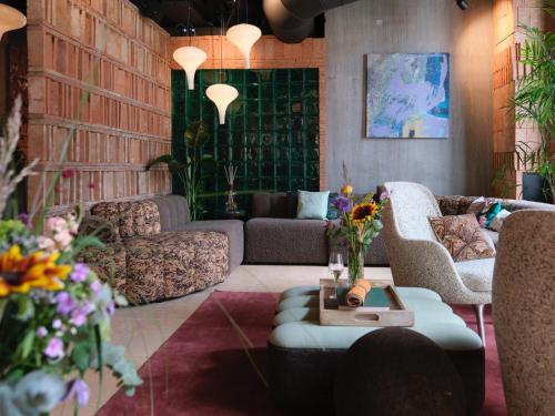 a living room with couches and a table and flowers at Belle Guldsmeden in Aarhus