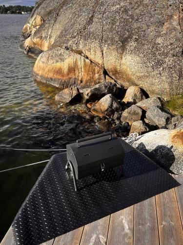 a speaker sitting on a dock next to a body of water at Stockholm Archipelago Igloo Hut in Tynningö