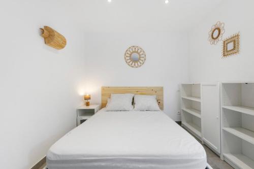 a bedroom with a white bed with white shelves at Villa Sandra - Le Verdon, Medoc in Le Verdon-sur-Mer