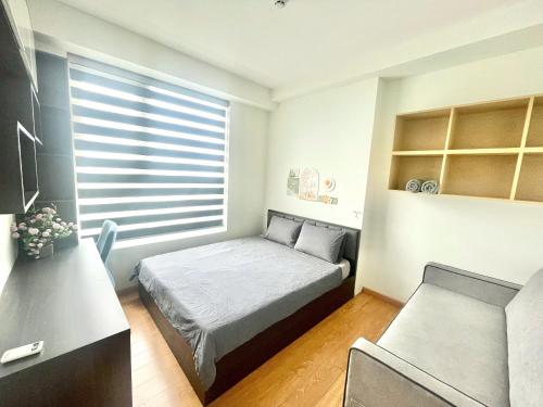a small bedroom with a bed and a desk at Saigon Getaway Apartment Thu Duc in Ho Chi Minh City