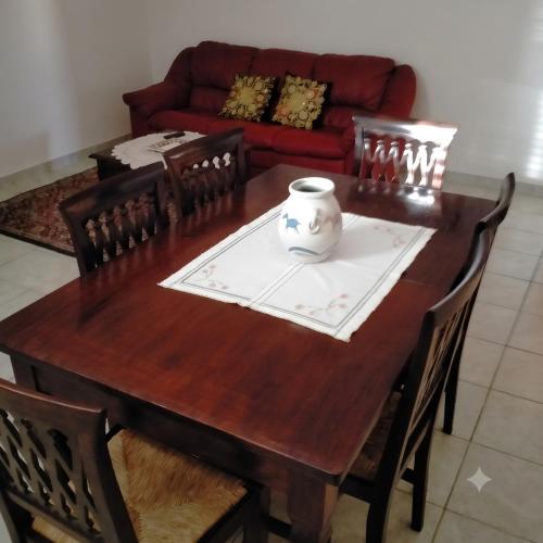 a wooden table with chairs and a vase on it at Casa dei Nipotini con Posto Auto Riservato in Paganica