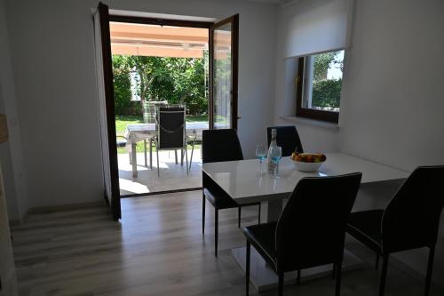 a dining room with a white table and chairs at Apartma Mija - XL in Kornić