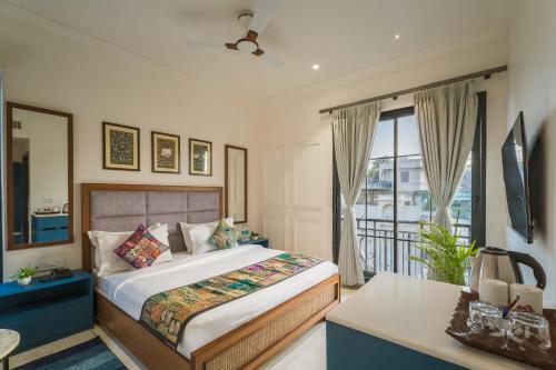 a bedroom with a bed and a balcony at Tripli Hotels Blue Moon in Udaipur