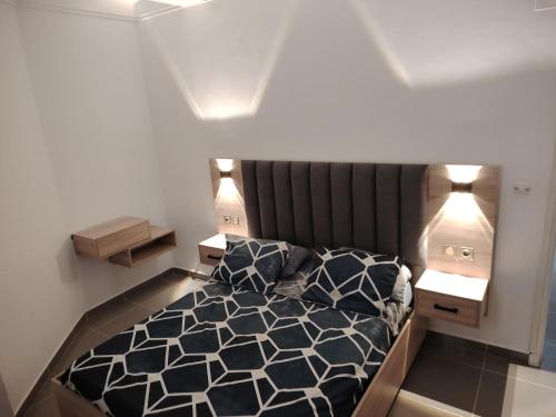 a bedroom with a black and white bed with two night stands at Dany house in Aïn El Turk