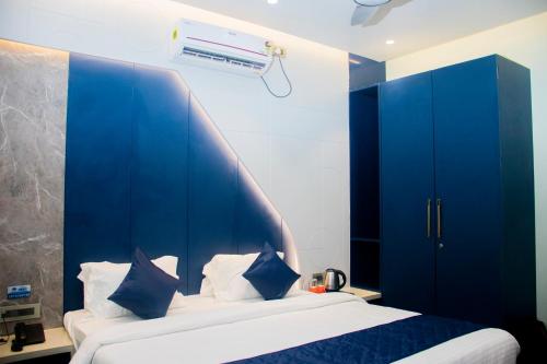 a bedroom with a blue headboard and a bed at Hotel Orbit in Parbhani