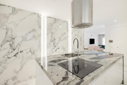 a kitchen with a marble counter with a sink at Apartamento Calafell Mar in Calafell