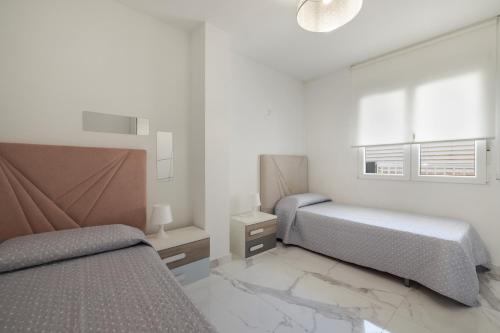 a bedroom with two beds and a window at Apartamento Calafell Mar in Calafell
