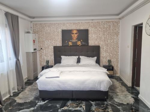a bedroom with a large bed and a painting on the wall at Casa Florentina in Făgăraş