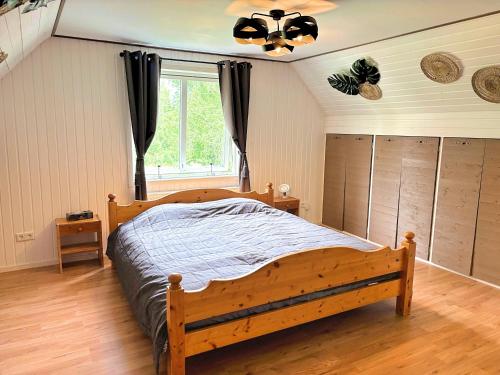 a bedroom with a wooden bed and a window at Hus Gillberga in Varmlands Nysater