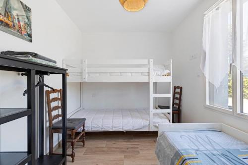 a bedroom with two bunk beds and a bed at La Maison Familiale in Commequiers