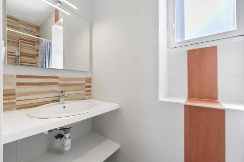 a bathroom with a sink and a mirror at La Maison Familiale in Commequiers