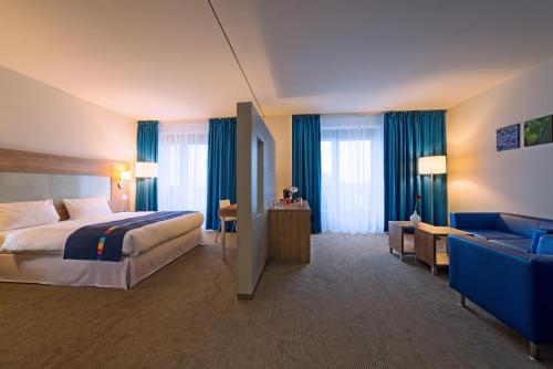 ein Hotelzimmer mit einem Bett und einem Sofa in der Unterkunft Quality Hotel Ostrava City in Ostrava