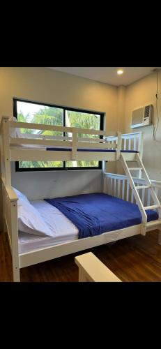a bedroom with two bunk beds and a window at Mystical Hidden Farmhouse in Camiguin