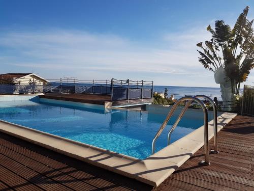 - une piscine sur une terrasse avec l'océan en arrière-plan dans l'établissement Appartement au Chateau Vallaya, à Menton