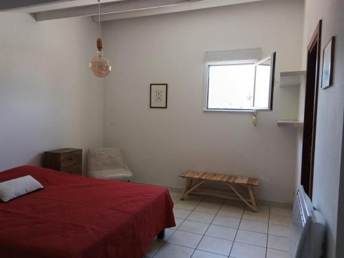 a bedroom with a red bed and a window at Maria beach in San-Nicolao