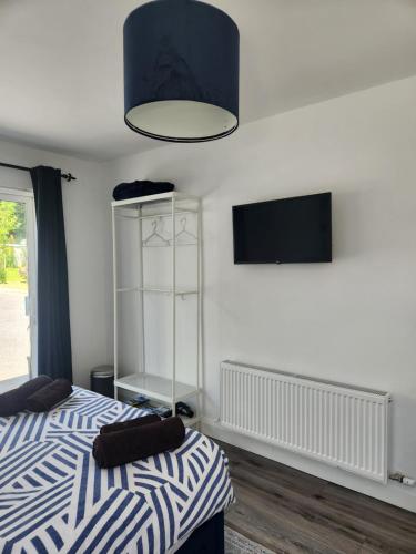 a bedroom with a bed and a tv on the wall at The Lodge in Killarney