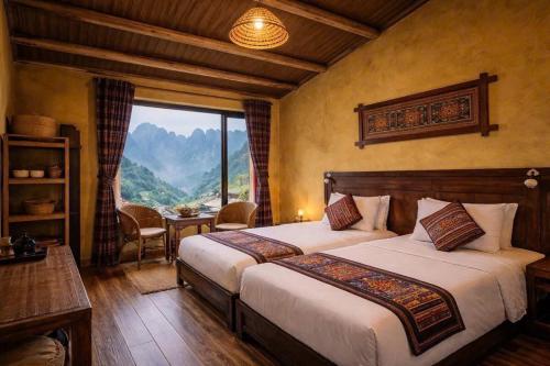 a bedroom with two beds and a view of a mountain at OH Pu Luong Homestay in Làng Bang