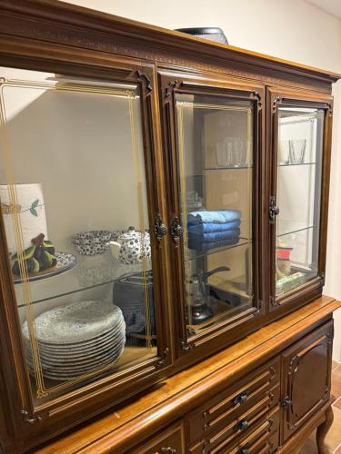 a wooden cabinet with glass doors with plates in it at Villa Brodetto, Sveti Stefan in Pržno
