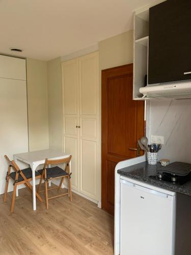 a small kitchen with a table and a table and a counter at Studio Indépendant in Floirac