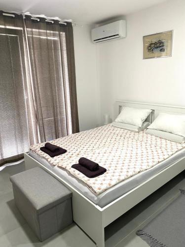 a bedroom with a bed with two towels on it at Apartman Beli Bagrem in Veliko Gradište