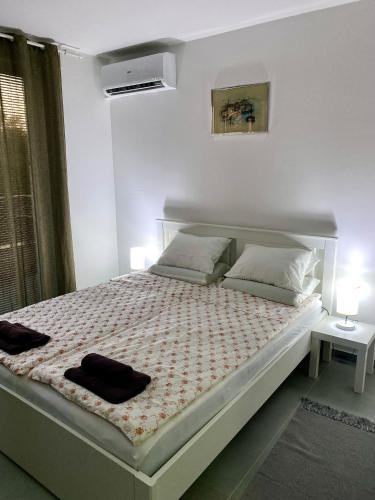 a bedroom with a large bed with two pillows at Apartman Beli Bagrem in Veliko Gradište
